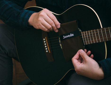 Man holding a Guitar and a Boveda pack.