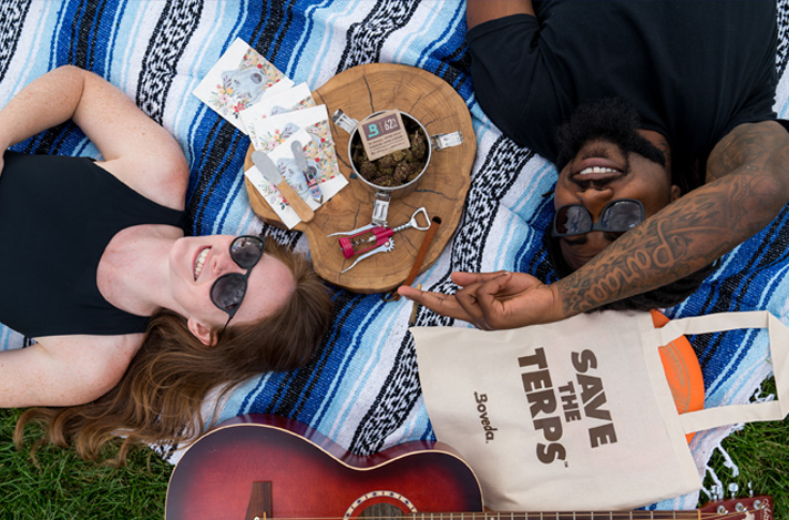 Two people laying on the ground enjoying a blunt