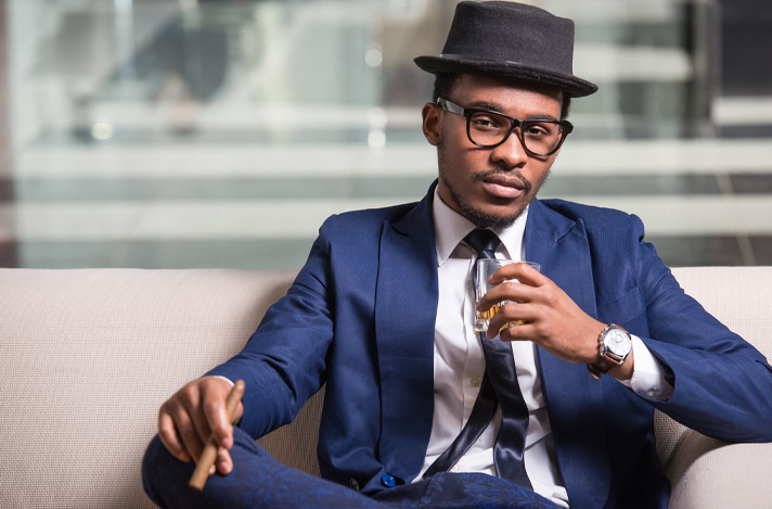 A man dressed in a suit with a cigar in hand