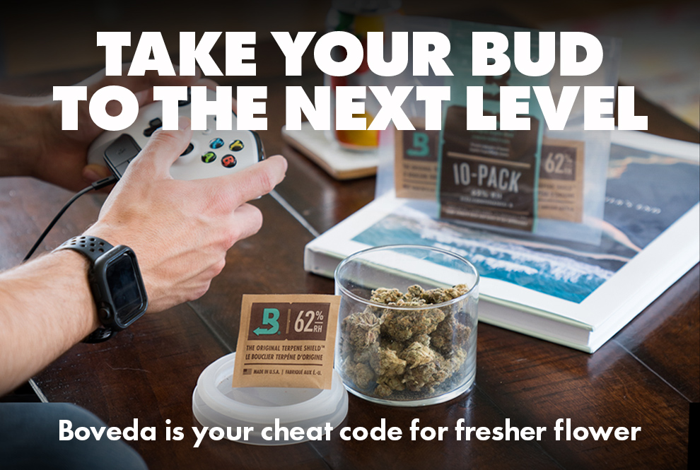 Male hands holding a game controller. Living room table with jar of cannabis and a size 8 62%RH Boveda. Also a 10-pack of 8 62%RH Bovedas.