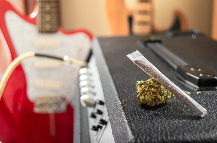 Cannabis on top of a guitar amp with a guitar in the background