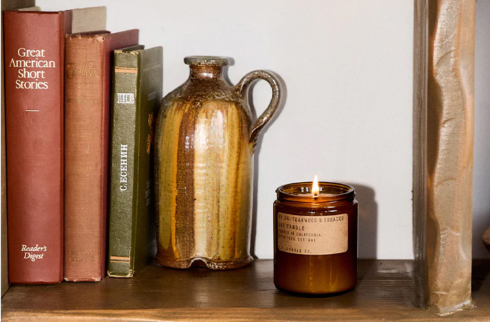 Tobacco scented candle on a book shelf